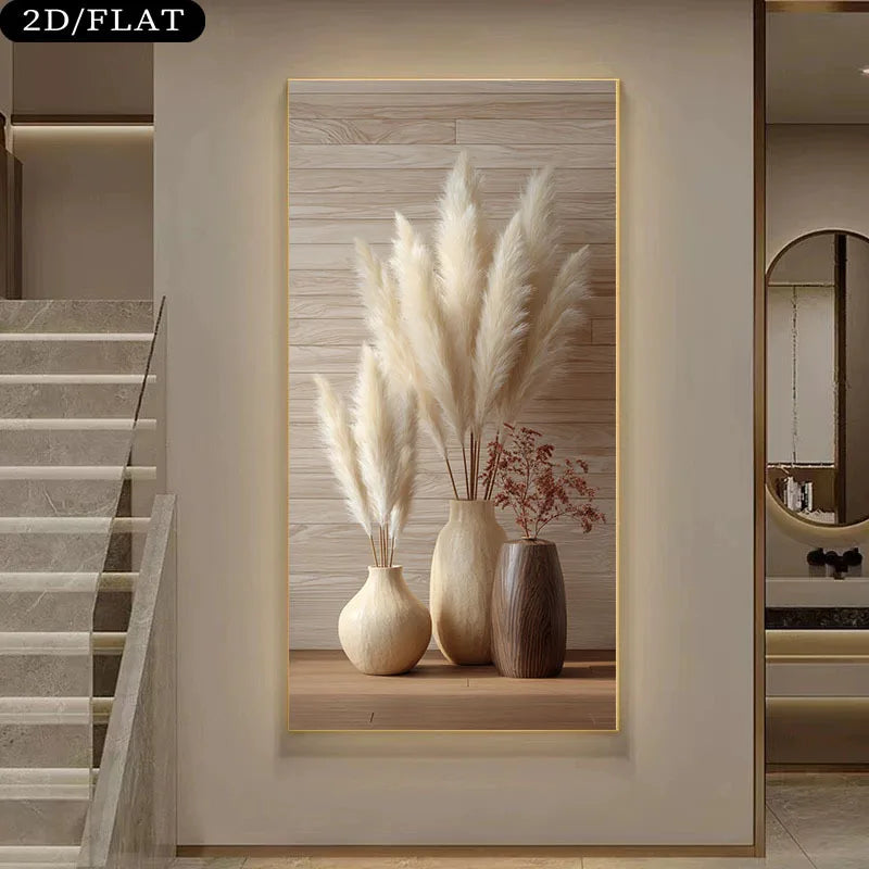 A wall art print displayed in a modern interior hallway. The artwork shows three beige and brown ceramic vases filled with tall cream pampas grass and small dried red stems, set against a light wood plank background with a thin gold frame.