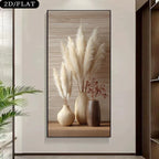 A wall art print showing three beige and brown vases with pampas grass and dried stems, displayed on a light wall in an interior setting.