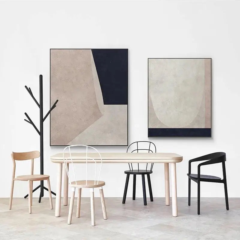 Modern dining area with a table, chairs, and abstract art on a white wall.