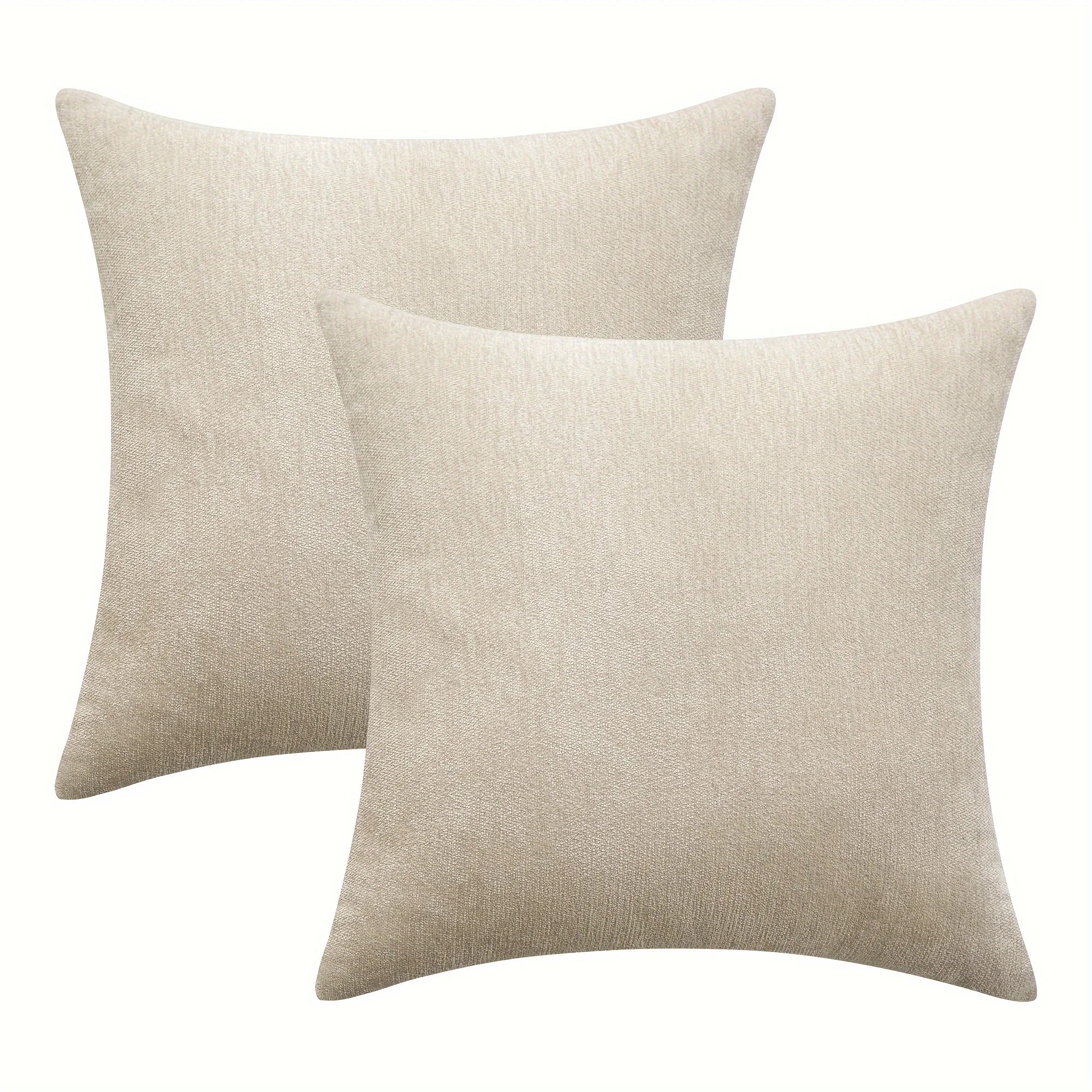 Two beige throw pillows on a white background