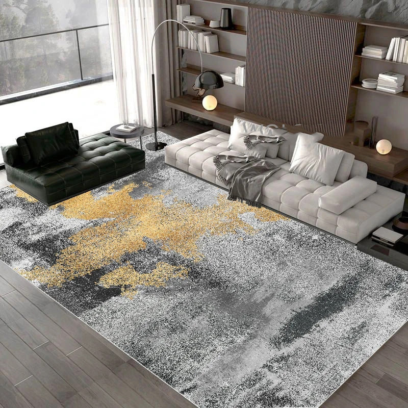 Modern living room with a gray and gold area rug, gray sofa, and bookshelf.