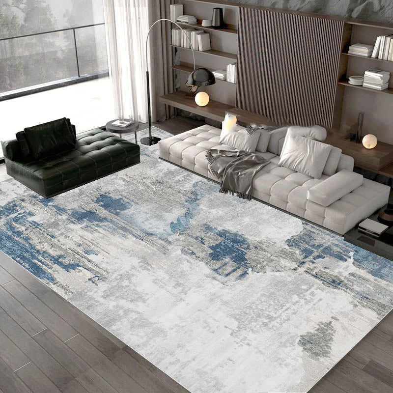 Modern living room with a patterned rug, gray sofa, and bookshelf.