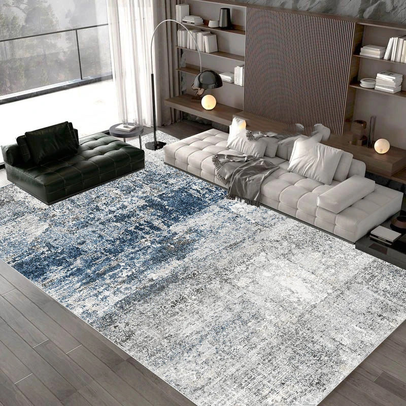 Modern living room with a patterned rug, gray sofa, and bookshelf.