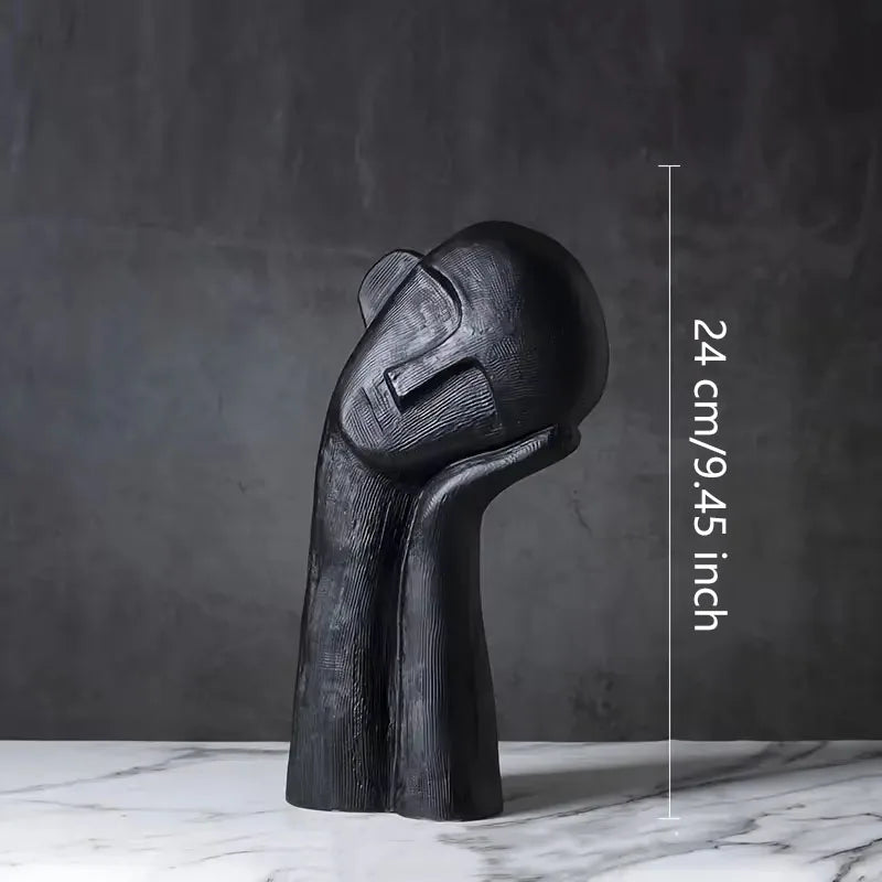Black abstract sculpture on a marble surface with measurements indicated