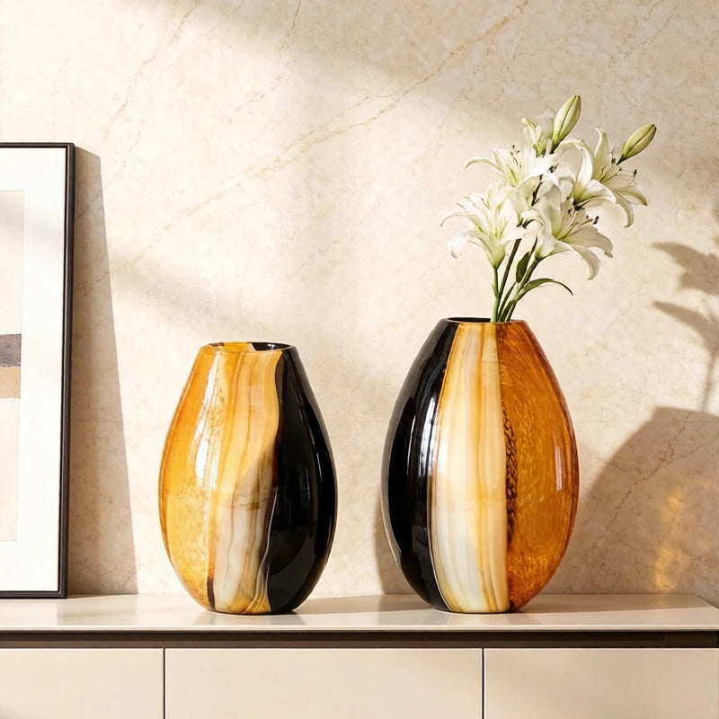 Two decorative vases with a floral arrangement on a shelf against a beige wall.