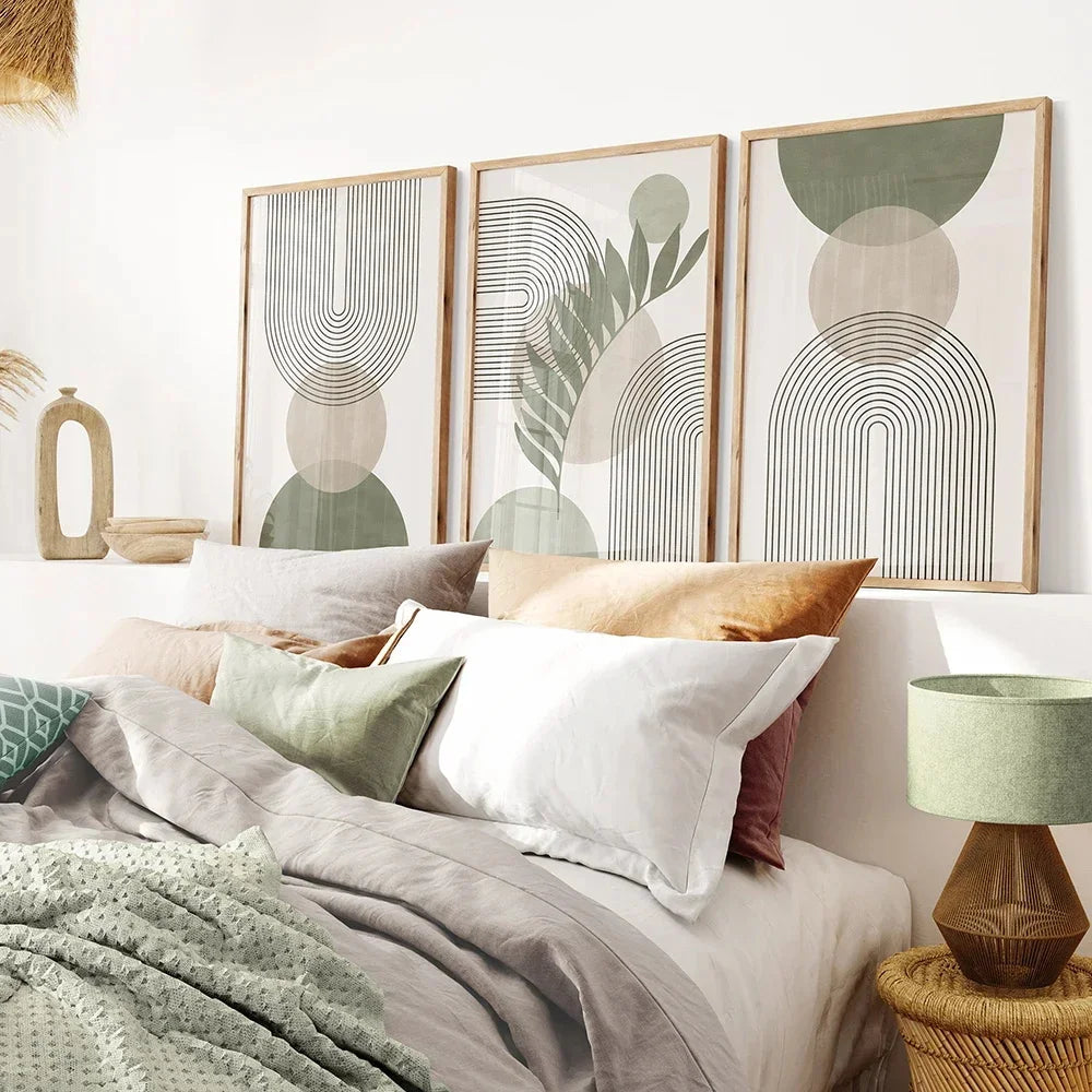 Decorative abstract art on a wall above a bed with pillows and a lamp.