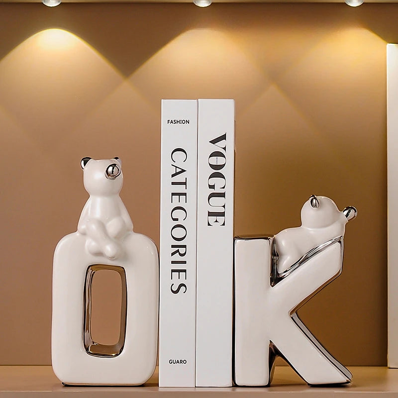 Decorative bookends shaped like a cat and a dog on top of books with 'Vogue' branding.