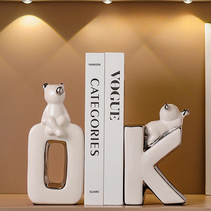 Decorative bookends shaped like cats on a shelf with a 'Vogue' magazine.
