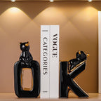 Black cat-shaped bookends on a shelf with a Vogue magazine in the background