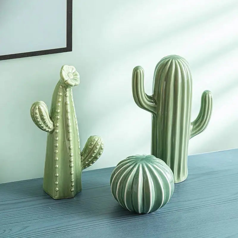 Three green cactus-shaped decorative items on a wooden surface with a light blue wall in the background.