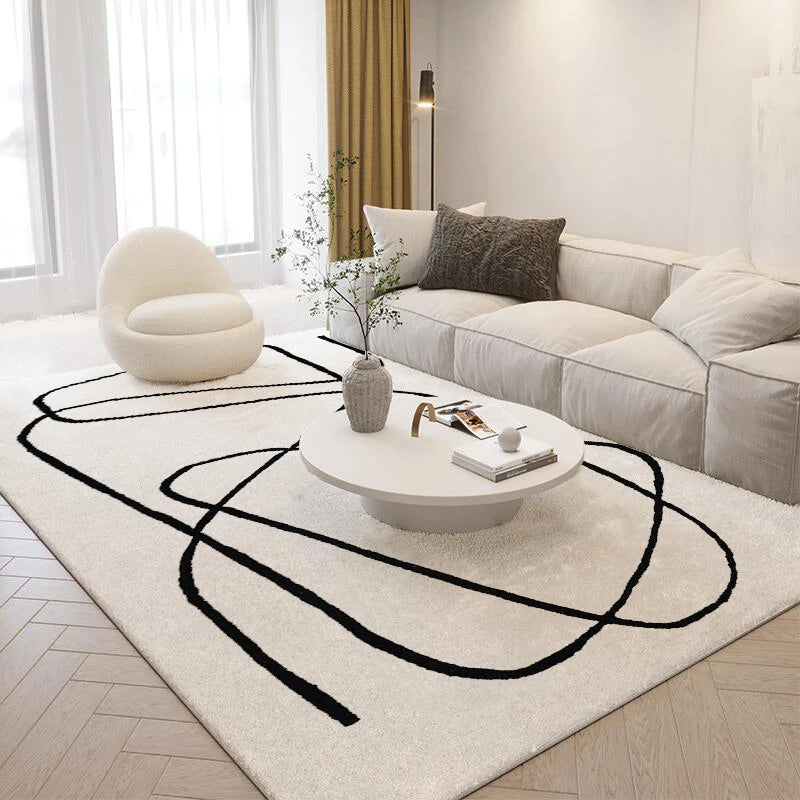 Modern living room with a white sectional sofa, round coffee table, and abstract black rug.