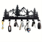 Key holder with mountain design holding various keys and items on a white background