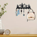 Wall-mounted key holder with decorative items on a wooden surface and light-colored wall background.