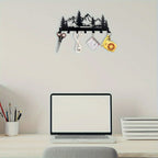 Wall-mounted key holder with nature design above a desk with laptop and stationery.