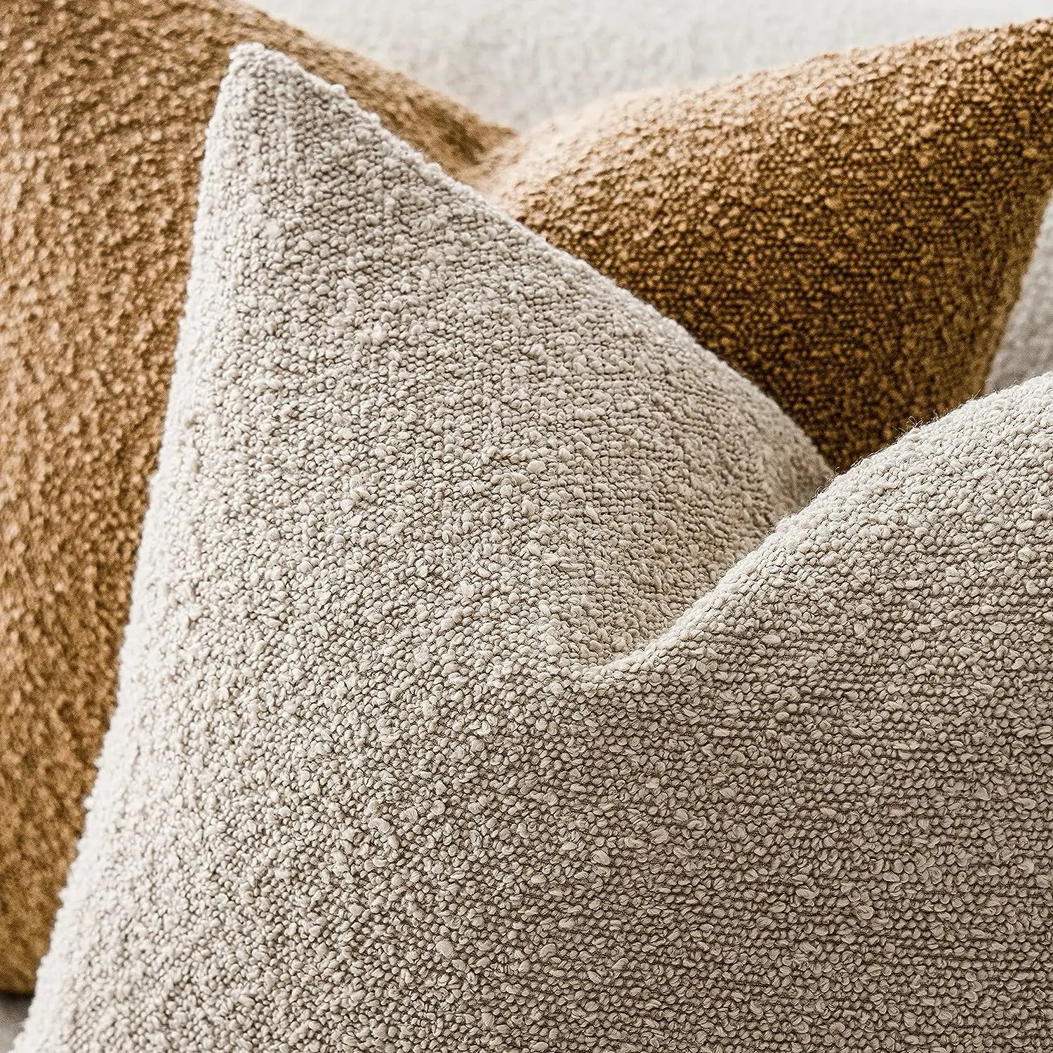 Close-up of textured beige pillows on a neutral background