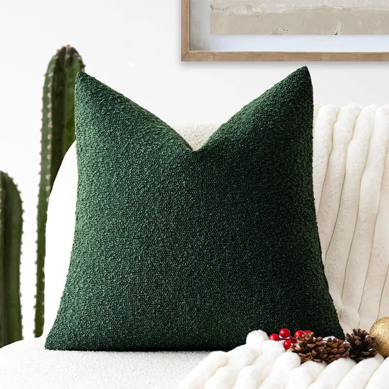 Green textured pillow on a white couch with decorative elements.