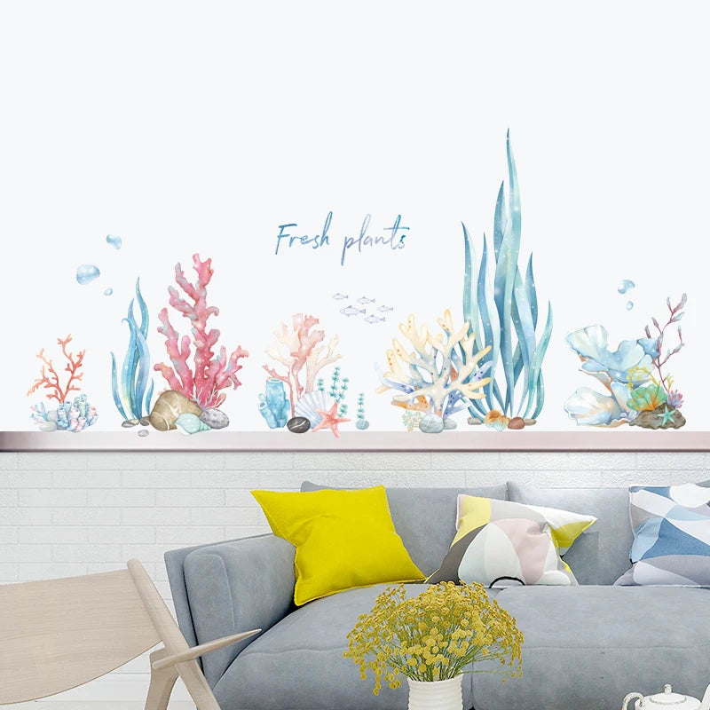 Decorative wall stickers of colorful plants on a white wall above a gray sofa with yellow and white cushions.