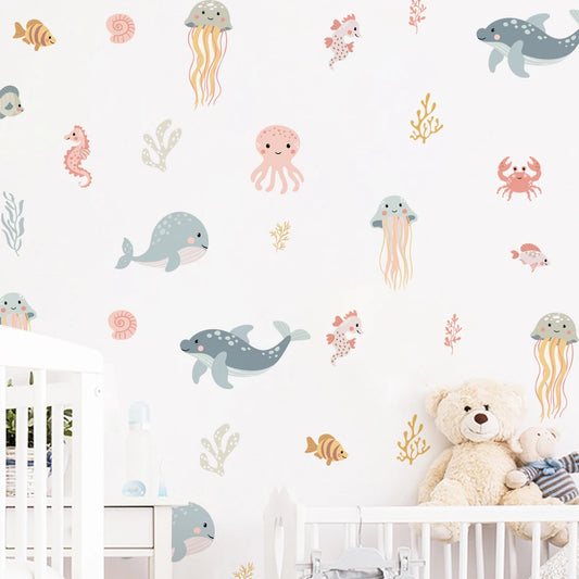 Children's room with crib, teddy bear, and wall stickers of sea creatures on a white wall.