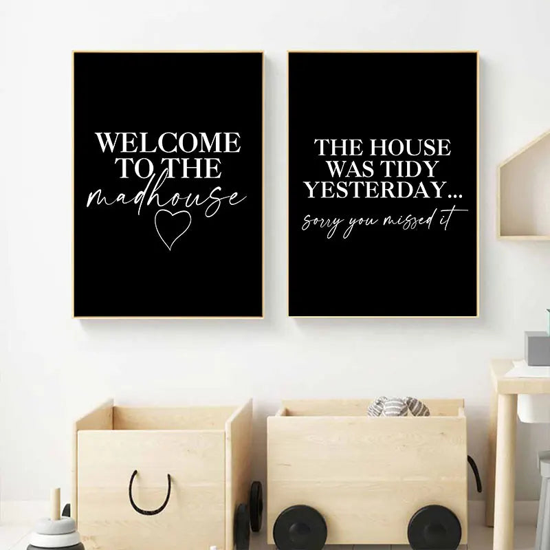 Two black posters with humorous text on a white wall above wooden storage boxes.