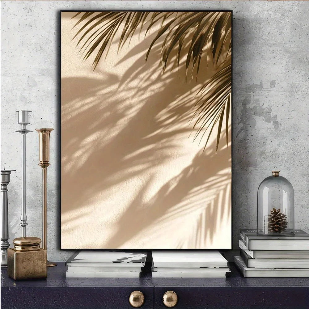 Framed artwork of palm leaves on a textured wall with decorative items below.