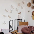 Children's bedroom with decorative wall stickers, a bed, and colorful pillows.