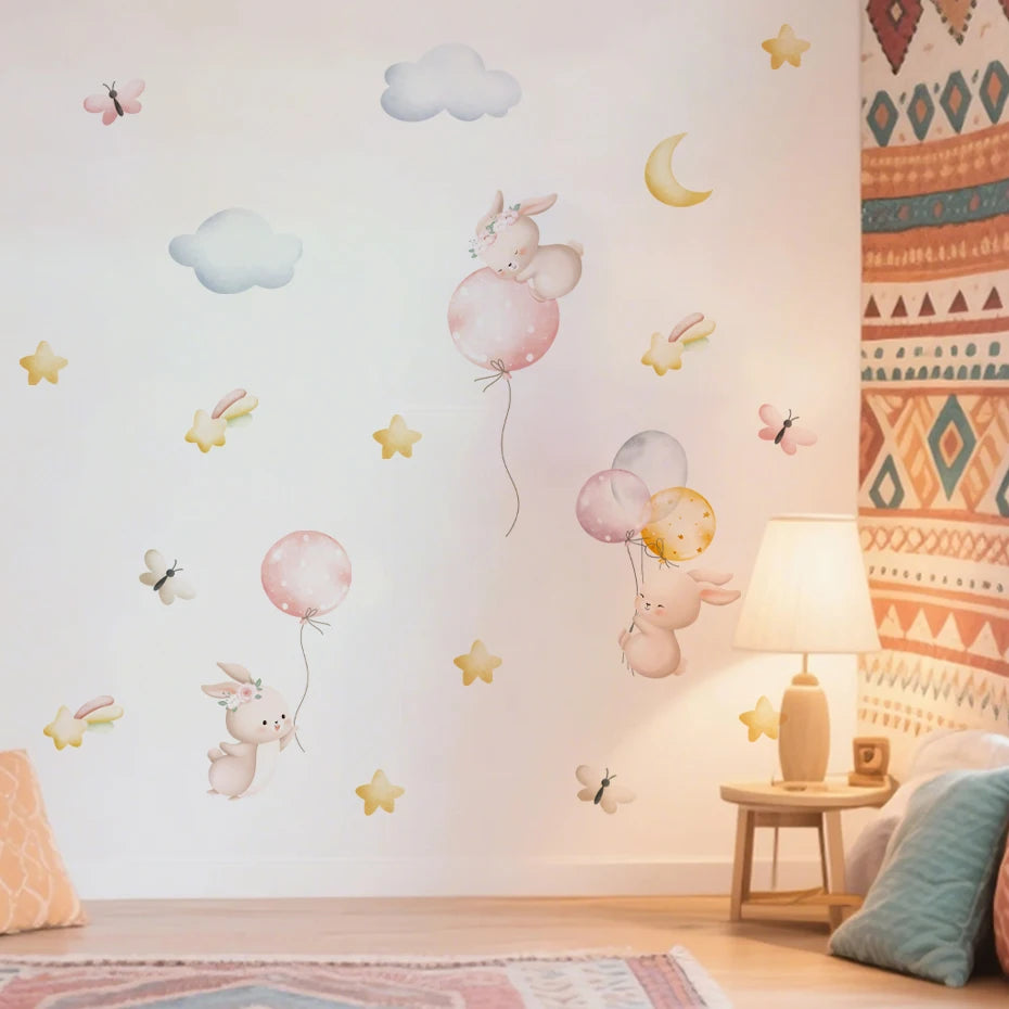 Children's room with decorative wall stickers of rabbits with balloons and clouds.