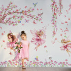 Young girl standing in front of a wall with fairy and floral decals