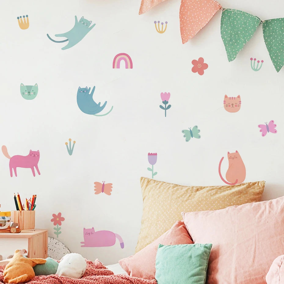 Children's room with colorful wall decals of cats, flowers, and butterflies on a light pink wall.