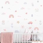Nursery room with crib and decorative wall stickers featuring animals, cars, and abstract shapes.