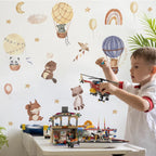 Child playing with toy helicopter in a room with wall decals of hot air balloons and animals.