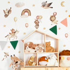 Children's room with wooden shelf displaying plush toys, wall stickers of animals and objects, and colorful flags.