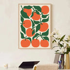 Framed artwork with orange and green design on a wall above a desk.