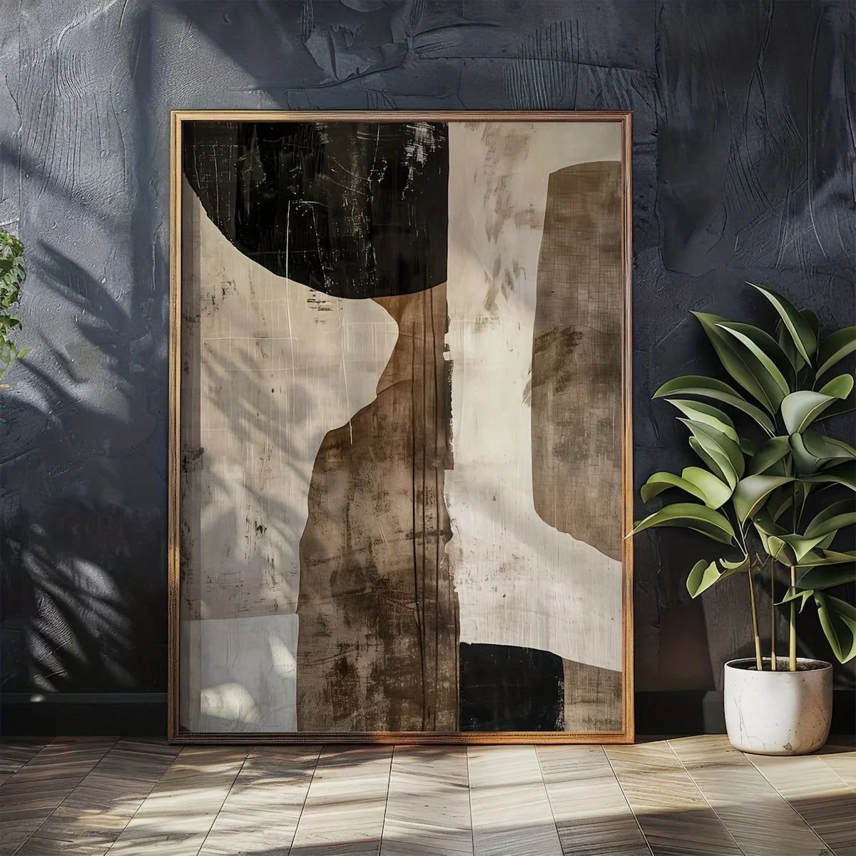 Abstract art piece in a gold frame on a dark wall with a plant to the right.