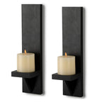 Two black wall-mounted candle holders with lit candles on a white background