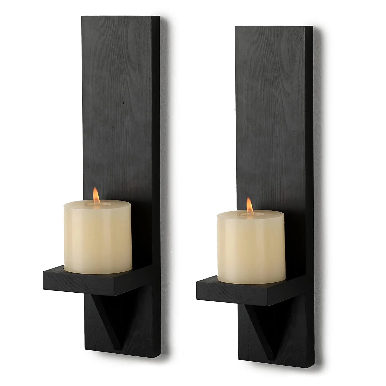 Two black wall-mounted candle holders with lit candles on a white background
