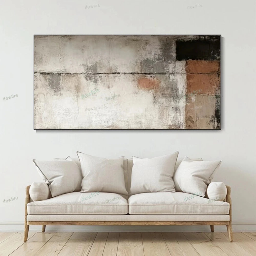 Beige sofa with white cushions in a room with a large abstract painting on the wall.