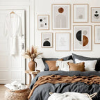 Cozy bedroom with abstract art on the wall, a bed with pillows, and a small table with decor items.