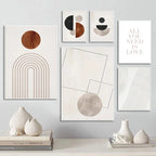 Wall with framed abstract art pieces and decorative vases on a shelf.