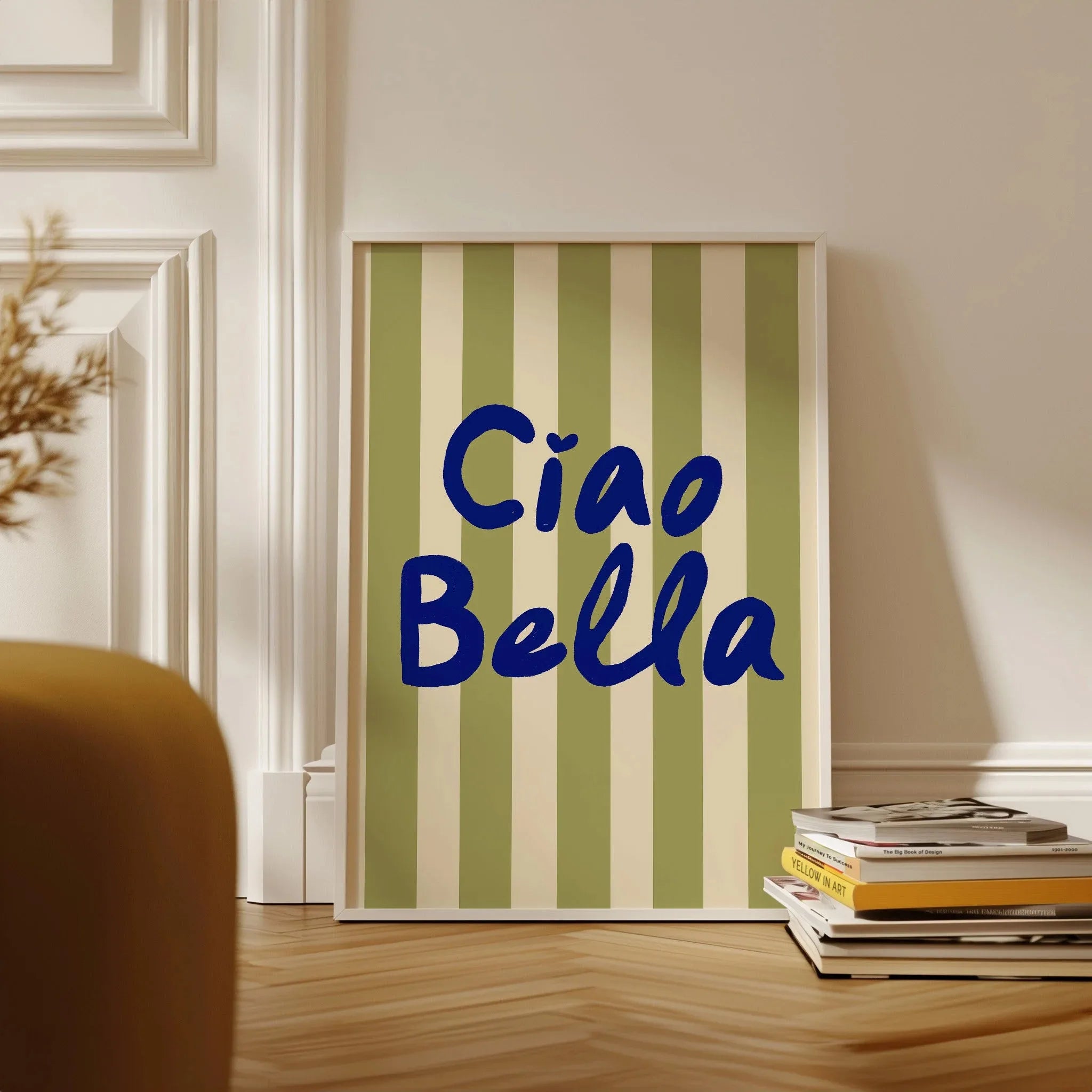 Framed artwork with 'Ciao Bella' text on a striped background in a room setting.