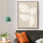 Abstract art piece on a wall above a sofa with decorative pillows and a plant.