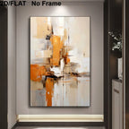 Abstract canvas wall art with expressive brushstrokes in orange, beige, white, and black, shown hanging on a gray wall in a modern interior setting. 