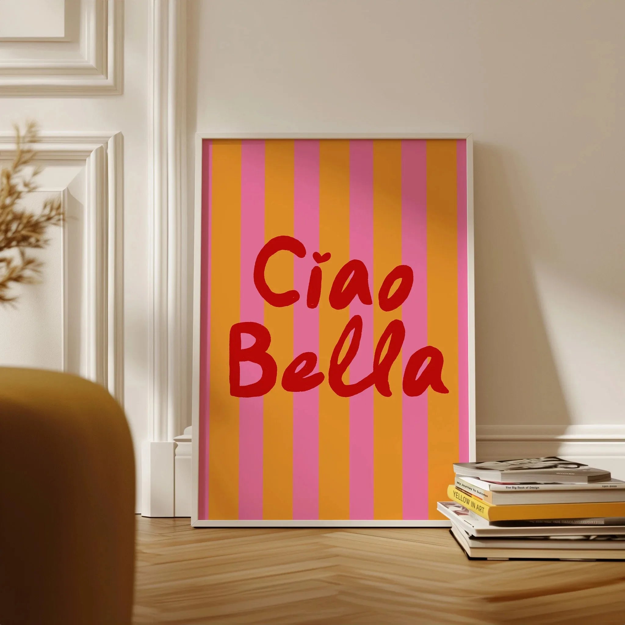 Framed artwork with 'Ciao Bella' text on a striped background in a room setting.