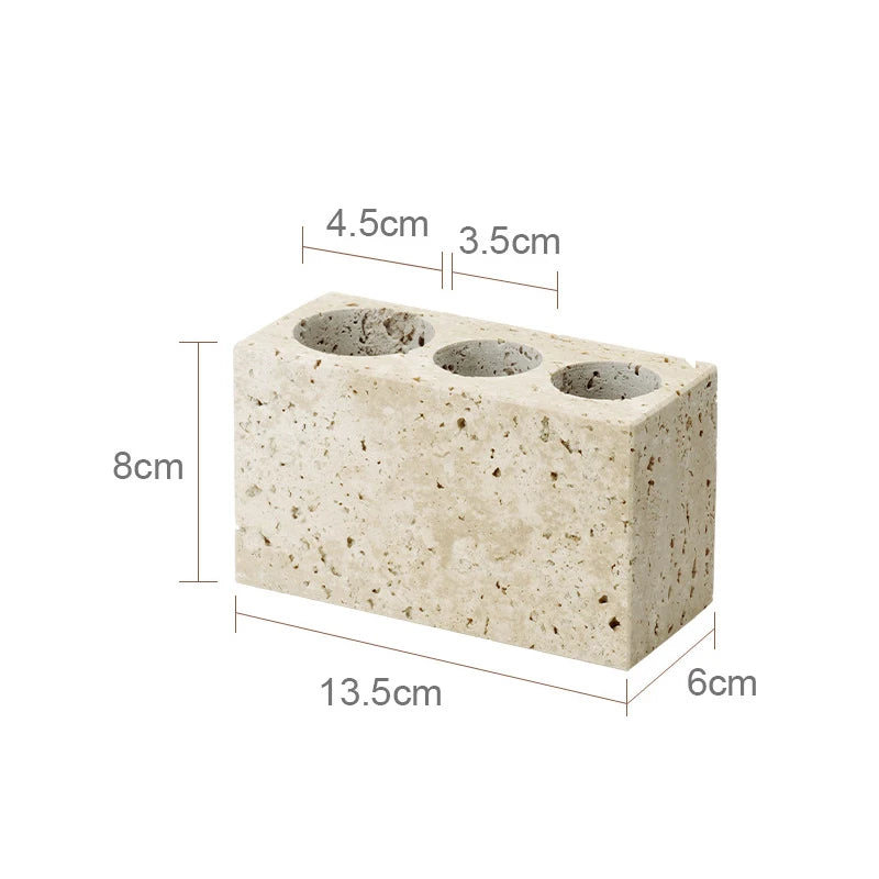 Concrete block with three cylindrical holes and dimensions labeled on a white background