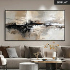 A large abstract canvas wall art print with black, white, beige, and gray brushstrokes, displayed above a modern gray sofa in a styled living room. 