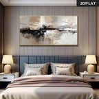 A framed abstract canvas painting in beige, black, and white tones hangs on a gray paneled wall above a bed with a dark gray tufted headboard and matching bedding. Two bedside tables with lit lamps flank the bed.