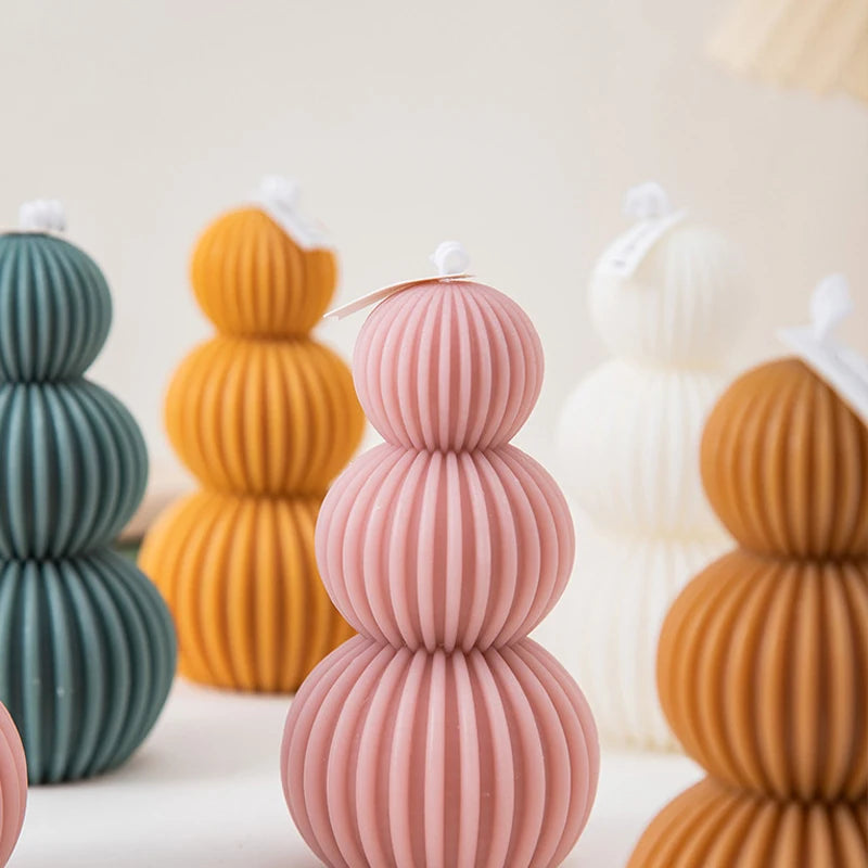 Stacked ribbed ceramic vases in various colors on a light background