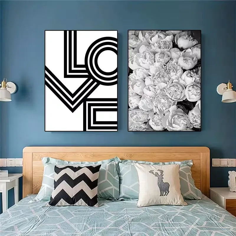 Two framed artworks on a blue wall above a bed with decorative pillows.