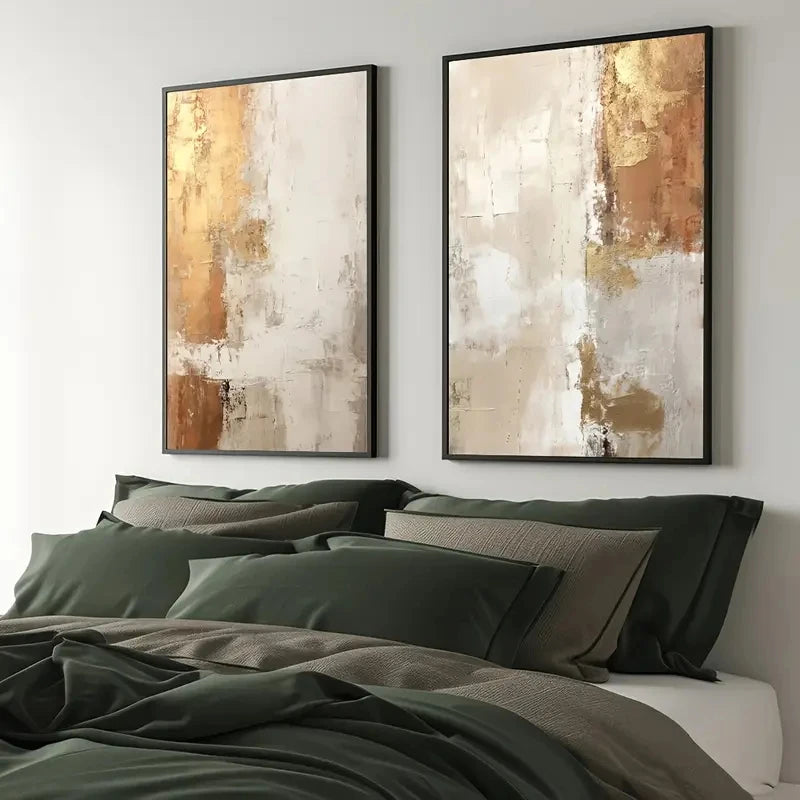 Two abstract art pieces on a wall above a bed with green bedding.