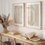Wooden console table with books and a vase, featuring two framed abstract artworks on the wall.