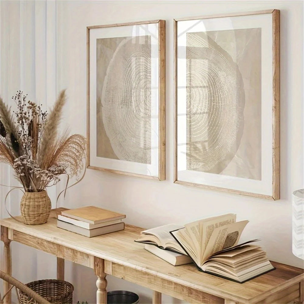 Wooden console table with books and a vase, featuring two framed abstract artworks on the wall.